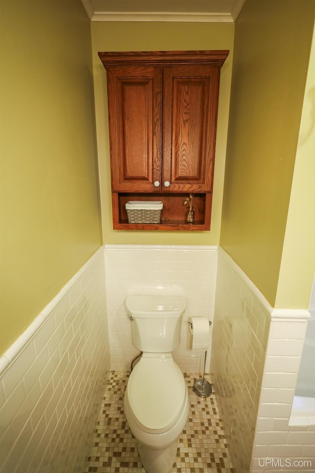 bathroom featuring tile patterned floors, toilet, tile walls, and crown molding