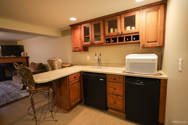 kitchen with dishwasher, sink, fridge, a kitchen bar, and kitchen peninsula