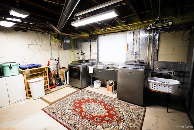 basement featuring washing machine and clothes dryer and sink