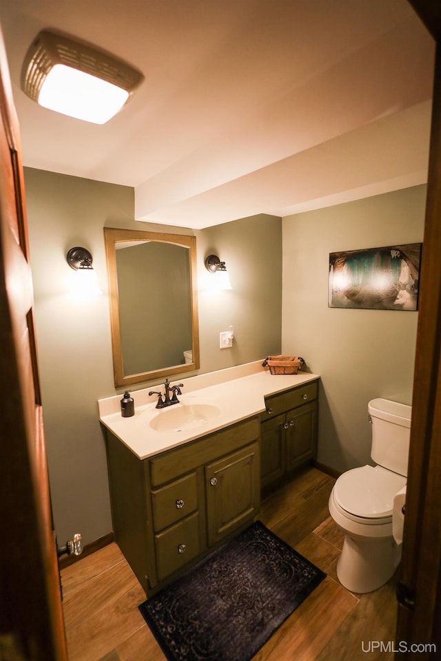 bathroom featuring toilet, vanity, and hardwood / wood-style flooring