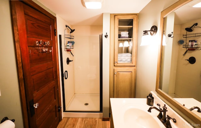 bathroom with hardwood / wood-style floors, vanity, and walk in shower