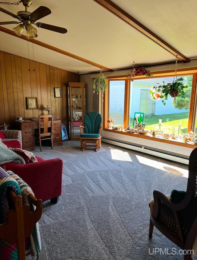 carpeted living room with beamed ceiling, ceiling fan, wooden walls, and a baseboard heating unit