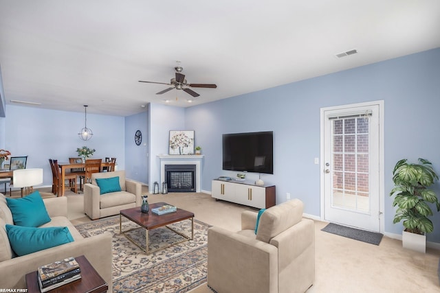 carpeted living room with ceiling fan