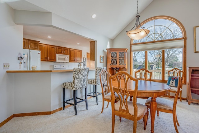 carpeted dining room featuring lofted ceiling and sink