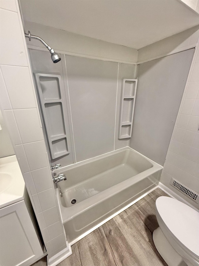 bathroom featuring hardwood / wood-style floors,  shower combination, and toilet