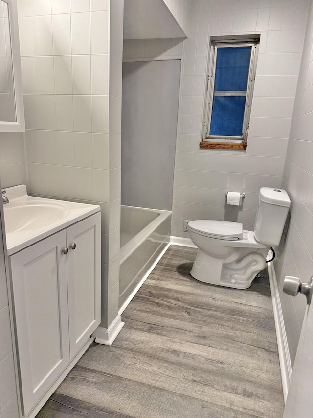 full bathroom with shower / tub combination, vanity, hardwood / wood-style flooring, and toilet