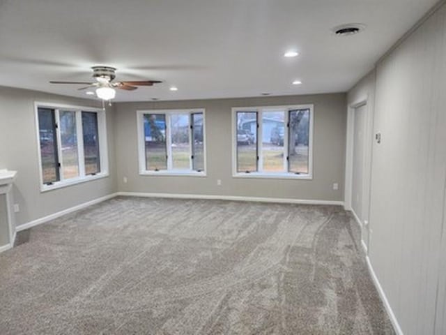 carpeted spare room with ceiling fan