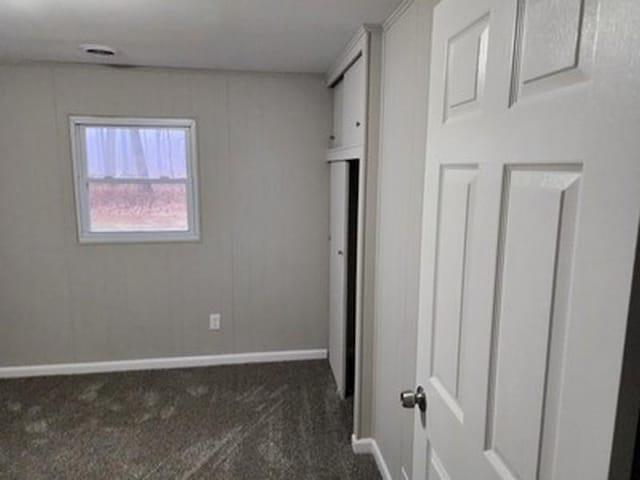 unfurnished bedroom with dark carpet