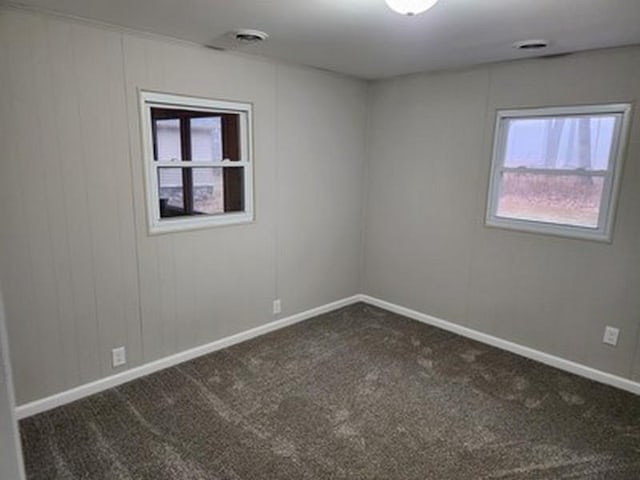 spare room with dark carpet