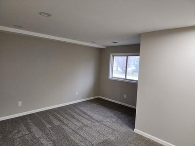 spare room with dark carpet