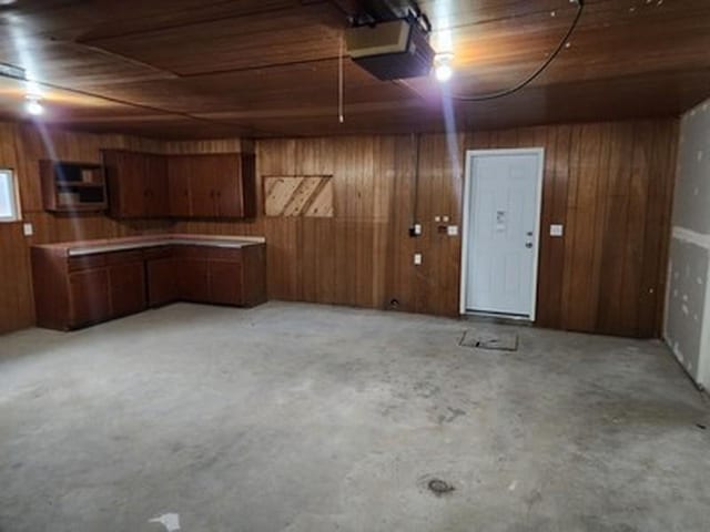 garage with wood walls, wooden ceiling, and a garage door opener