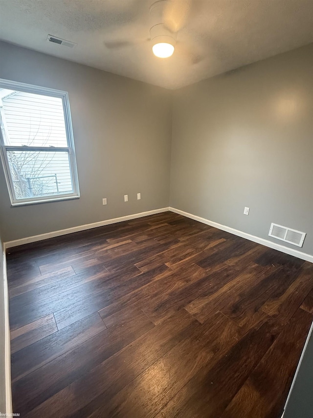 unfurnished room with ceiling fan and dark hardwood / wood-style floors