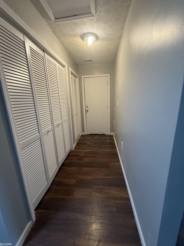 hallway featuring dark hardwood / wood-style floors and a textured ceiling