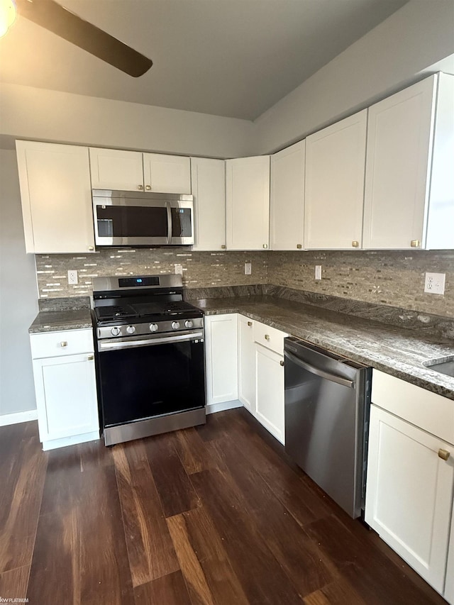 kitchen featuring dark stone counters, dark hardwood / wood-style floors, decorative backsplash, appliances with stainless steel finishes, and white cabinetry