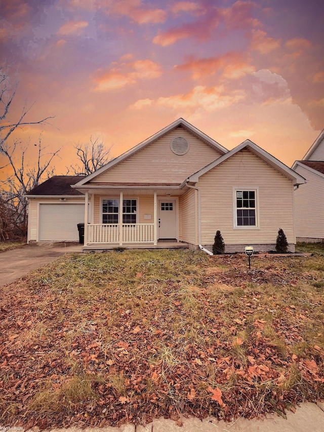 ranch-style home featuring covered porch, a yard, and a garage