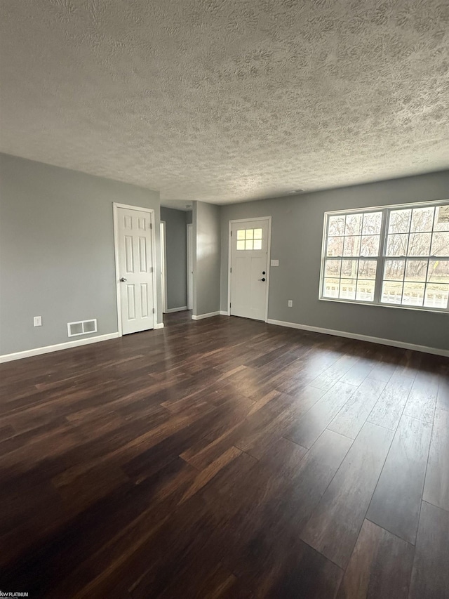 interior space with a textured ceiling and dark wood-type flooring