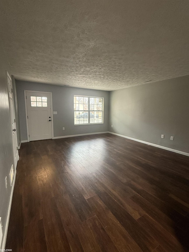 interior space with a textured ceiling, dark hardwood / wood-style flooring, and a healthy amount of sunlight