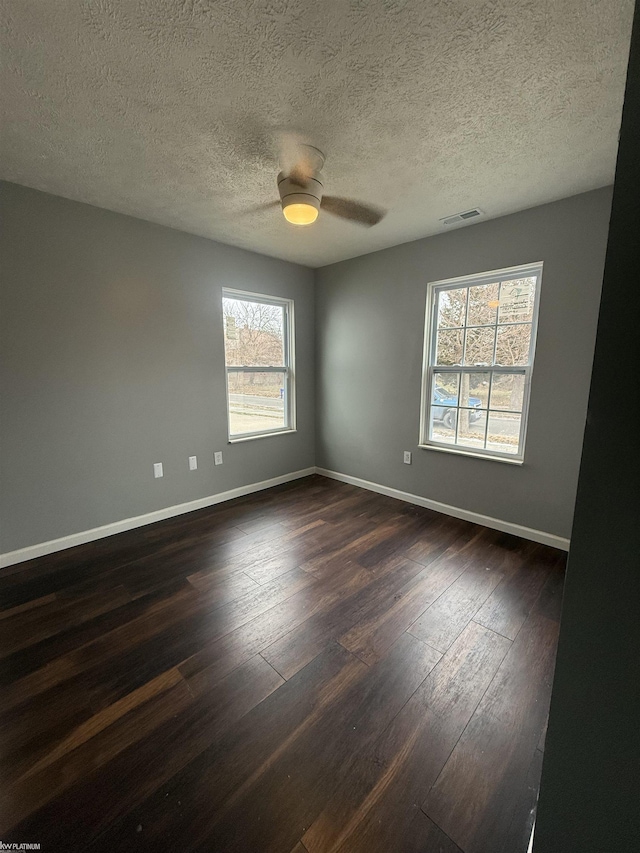 unfurnished room featuring ceiling fan, dark hardwood / wood-style flooring, and a textured ceiling