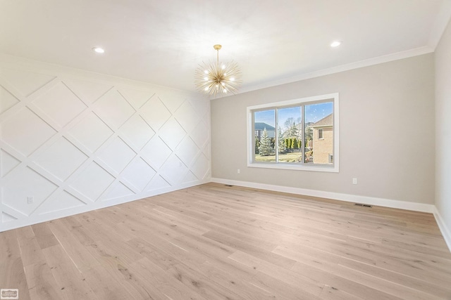 unfurnished room featuring a notable chandelier, ornamental molding, and light hardwood / wood-style flooring