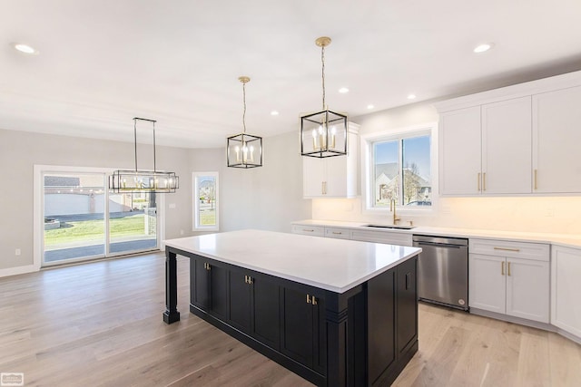 kitchen with dishwasher, a center island, sink, hanging light fixtures, and white cabinetry