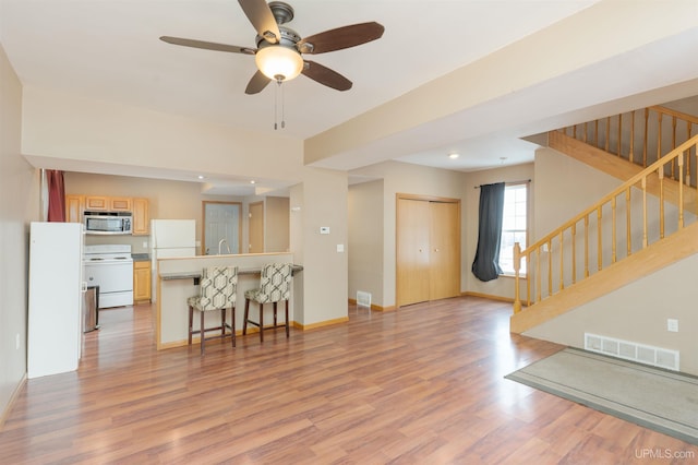 living room with ceiling fan, sink, and light hardwood / wood-style flooring