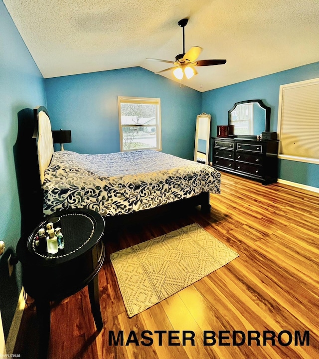 bedroom featuring hardwood / wood-style floors, ceiling fan, a textured ceiling, and vaulted ceiling