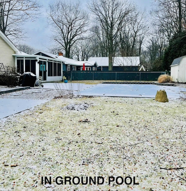 yard layered in snow featuring a sunroom