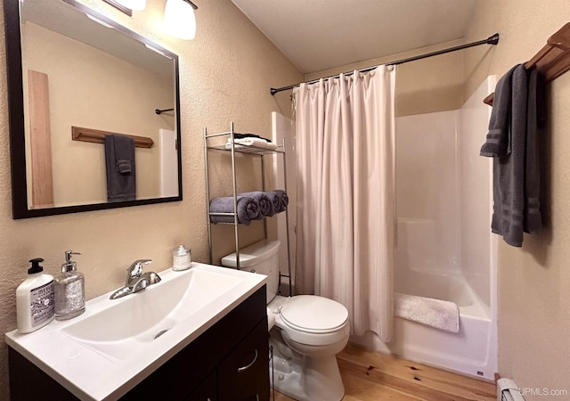 full bathroom with hardwood / wood-style floors, vanity, a baseboard heating unit, toilet, and shower / bathtub combination with curtain