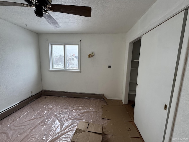 unfurnished bedroom featuring a textured ceiling, a closet, and ceiling fan