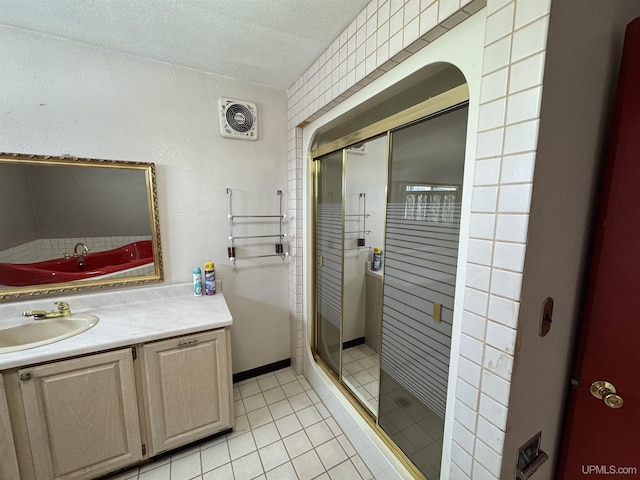 bathroom featuring a textured ceiling, vanity, tile patterned floors, and a shower with shower door