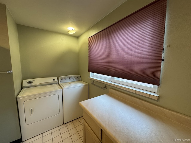 laundry area featuring cabinets, washing machine and dryer, and light tile patterned floors