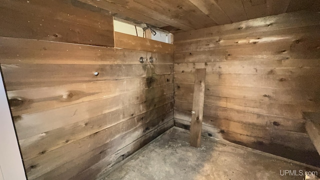 bathroom featuring wood walls, wooden ceiling, and concrete flooring