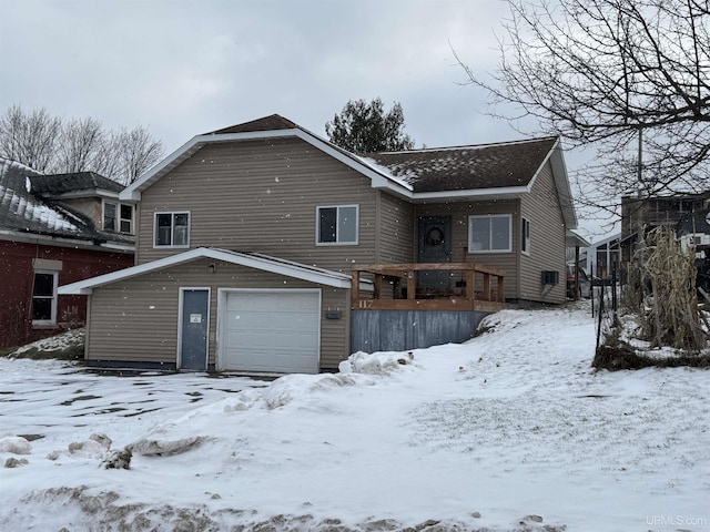 snow covered property with a garage