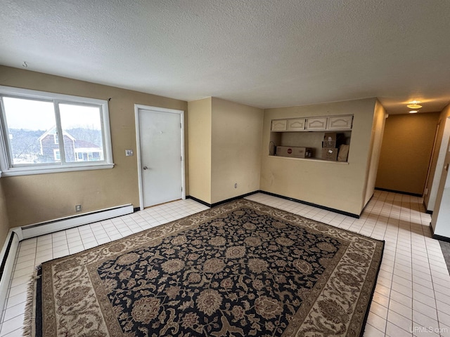 interior space featuring a textured ceiling, baseboard heating, and light tile patterned flooring