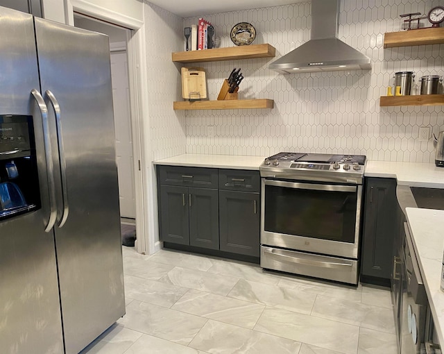 kitchen with backsplash, light stone counters, wall chimney exhaust hood, and appliances with stainless steel finishes