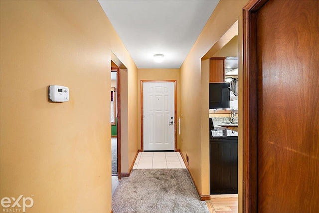 corridor with light colored carpet and sink