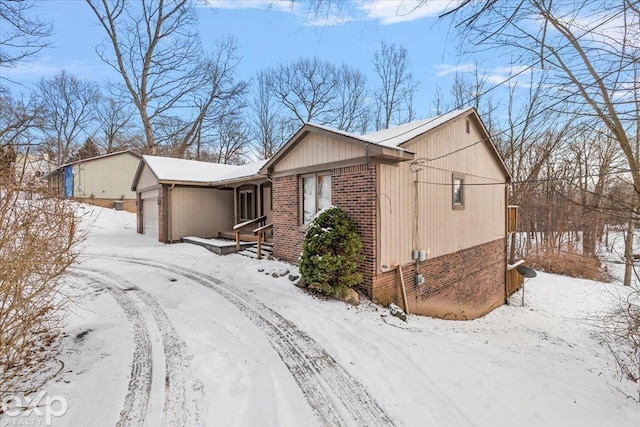 view of snow covered exterior with a garage