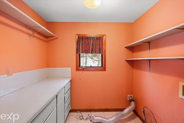 laundry area featuring cabinets and light tile patterned floors