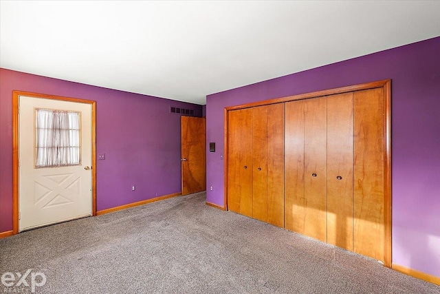 unfurnished bedroom featuring a closet and light colored carpet