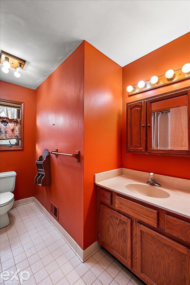 bathroom with tile patterned flooring, vanity, and toilet