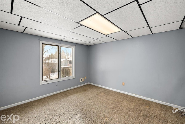 empty room with a drop ceiling and carpet floors