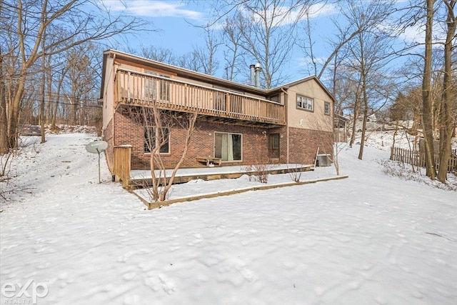 snow covered house featuring a wooden deck