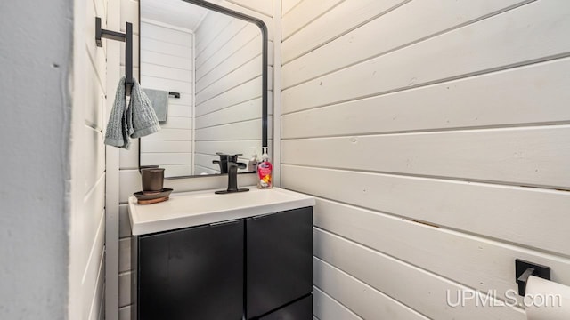 bathroom featuring wood walls and vanity