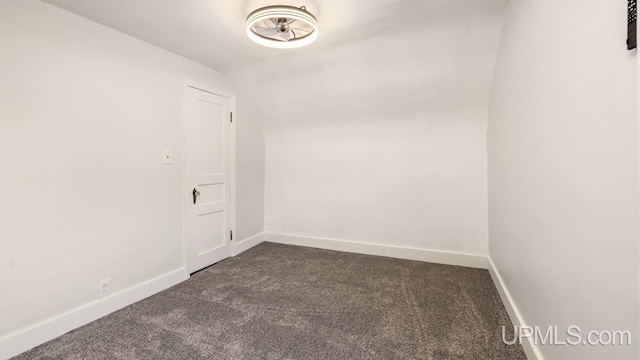 carpeted spare room featuring lofted ceiling