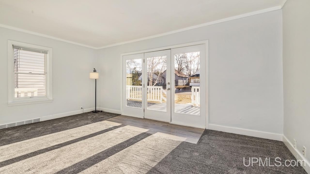 carpeted spare room featuring french doors and crown molding