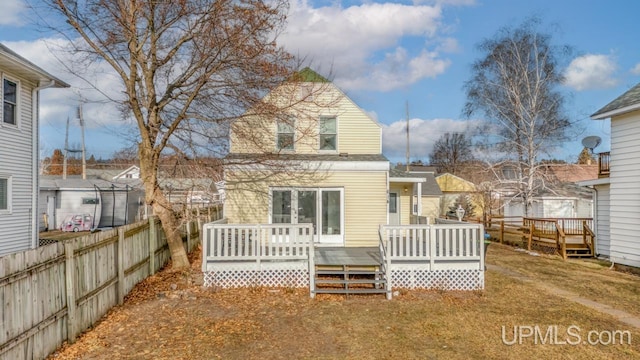 rear view of property featuring a deck and a yard