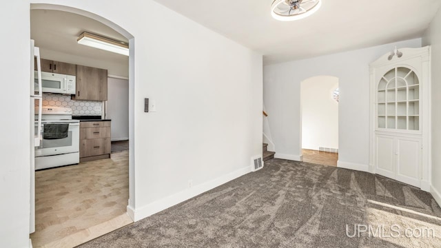 kitchen featuring tasteful backsplash, light colored carpet, and white appliances