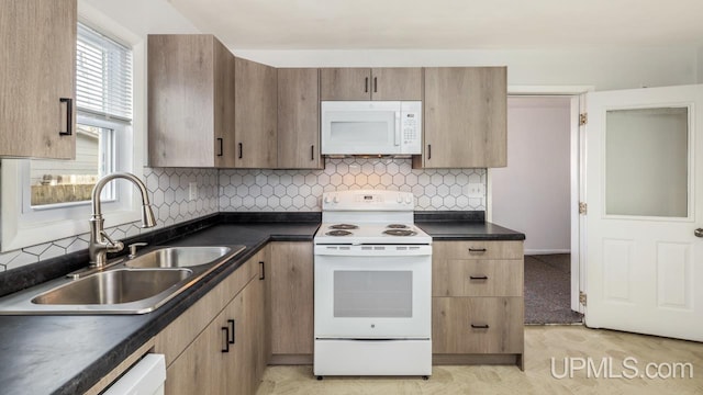 kitchen with decorative backsplash, white appliances, and sink