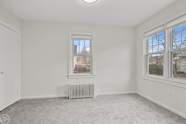 empty room featuring radiator heating unit and carpet floors