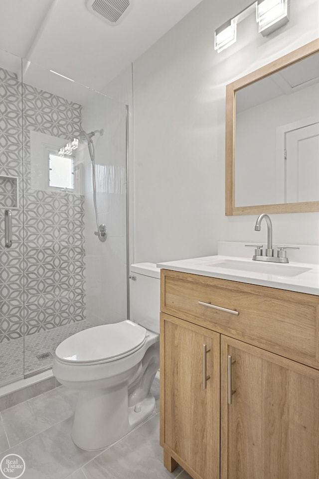 bathroom featuring toilet, vanity, tile patterned floors, and an enclosed shower